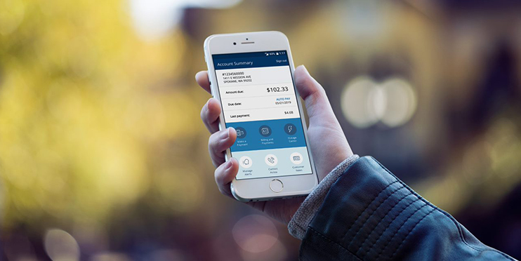 Person's hand holding mobile phone using Avista mobile app