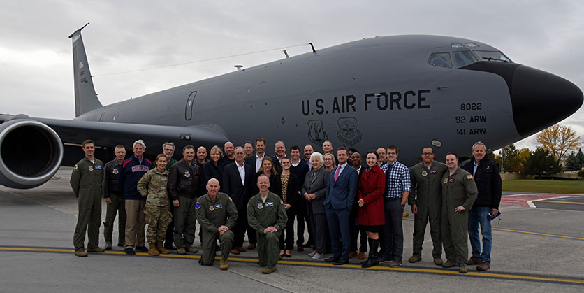 Active duty military and civilians standing in front of a US Air Force plane