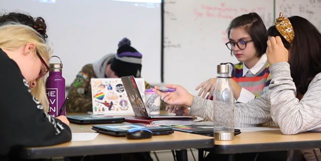 Students at the community school working together on laptops