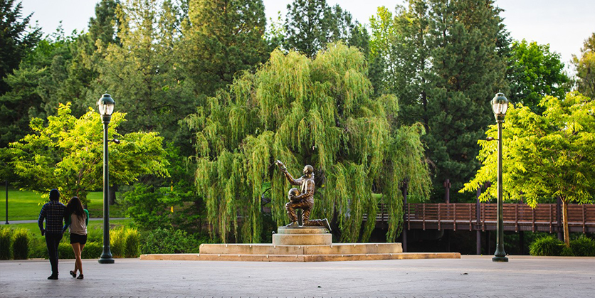 Sculpture in the park, downtown Spokane. Two people with their backs to the camera off to the side of the photo, looking at the sculpture