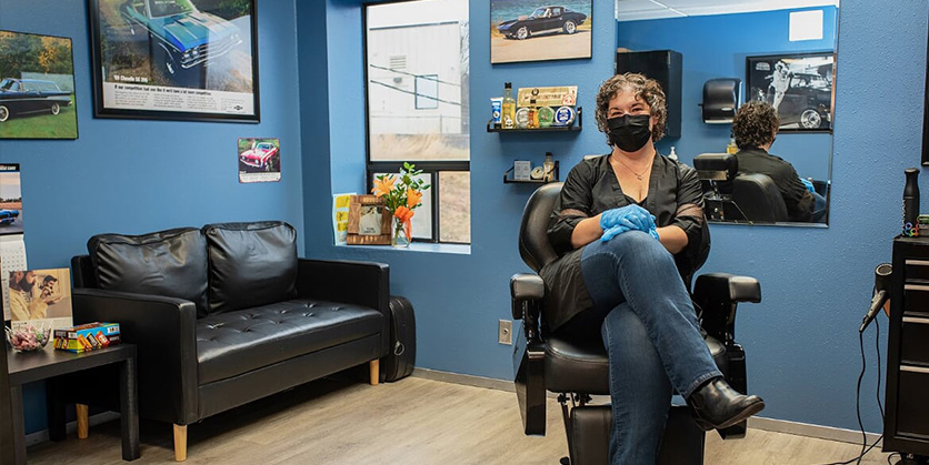 Woman sitting in barber's chair at a new barbershop