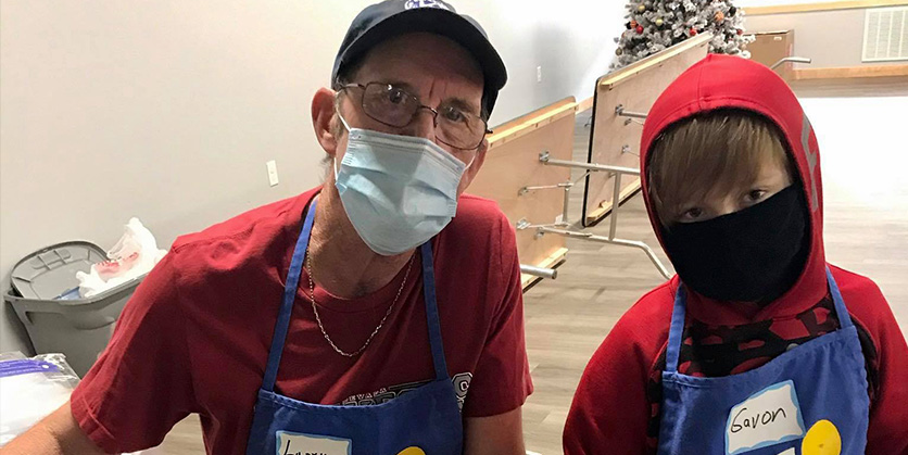 Man and little boy wearing masks and aprons