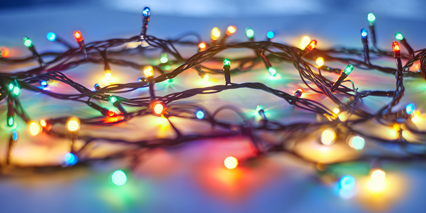 Holiday lights lit up on a dark blue background