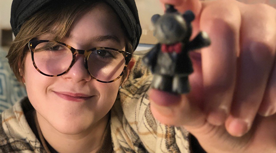 Girl smiling and holding a clay animal she made