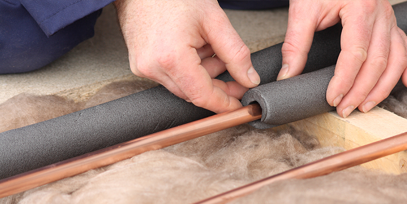 Closeup of someone's hands applying installation to water pipes