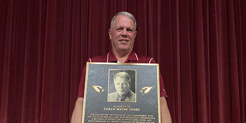 Man holding a large bronze plaque