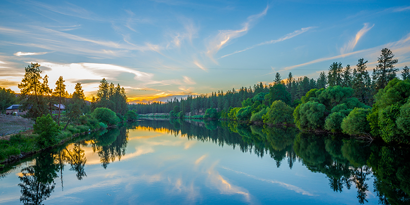Colorful sunset over a river lined with trees