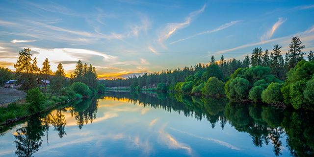 Colorful sunset over a river lined with trees