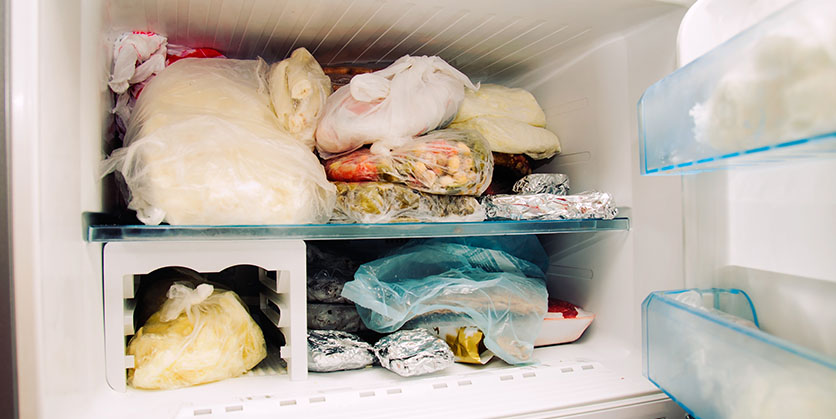 Opened freezer filled with frozen food
