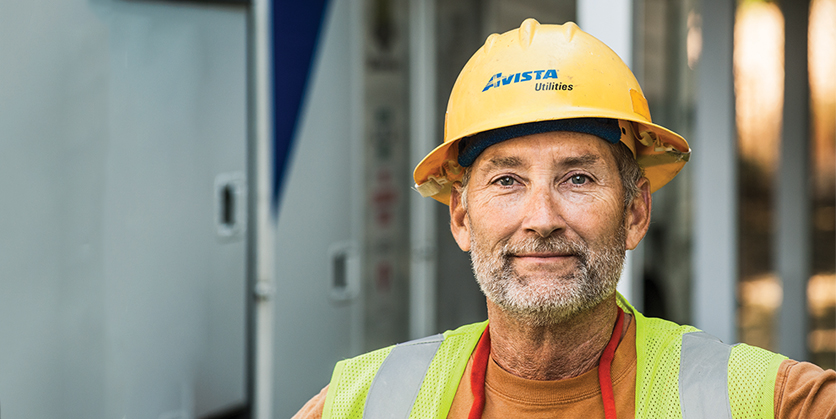 Closeup of Avista employee wearing Avista hardhat and yellow safety vest