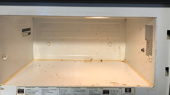 Closeup of the inside of a dirty microwave