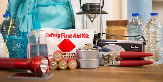 Emergency prepardness supplies including lashlight, backpack, batteries, water bottles, first aid kit, lantern, radio, can opener