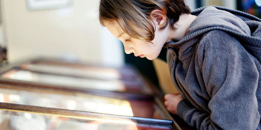 Child looking into a display case at Malin musuem