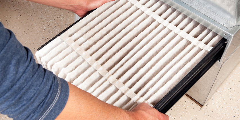 Closeup of a person replacing a furnace filter