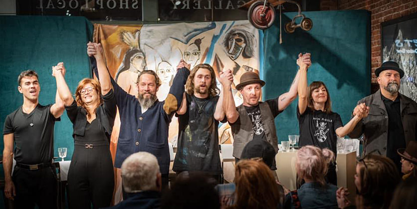 Actors and actresses at Drawn Together Arts theater holding hands at the end of a show