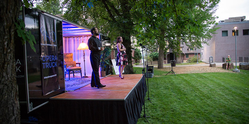 Opera truck outside with two performers on the stage