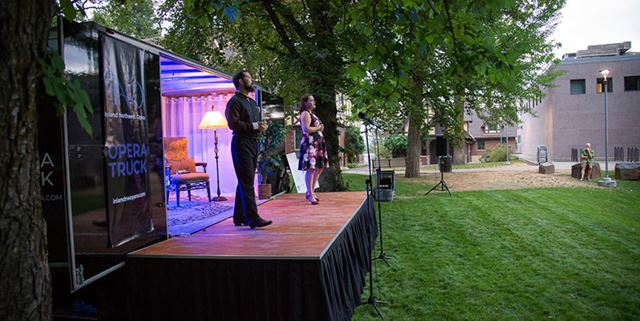 Opera truck outside with two performers on the stage
