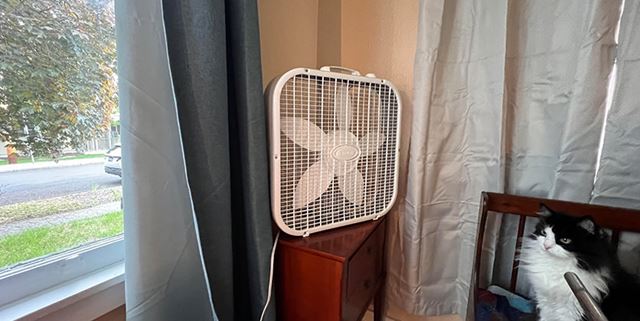 A box fan sits in the corner of a room