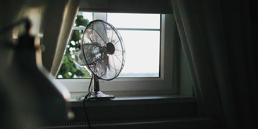 Fan sitting on a windowsill 