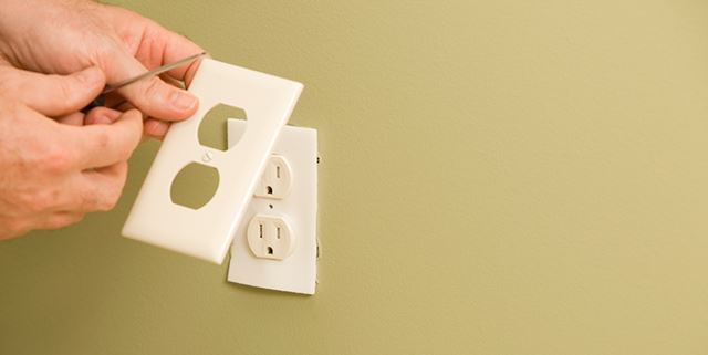 Installing foam insulator behind a power outlet