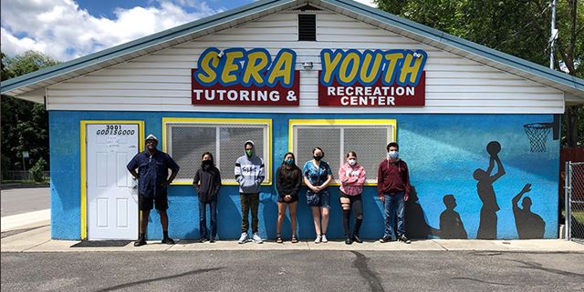 Kids and adult standing outside in front of Sera Youth building