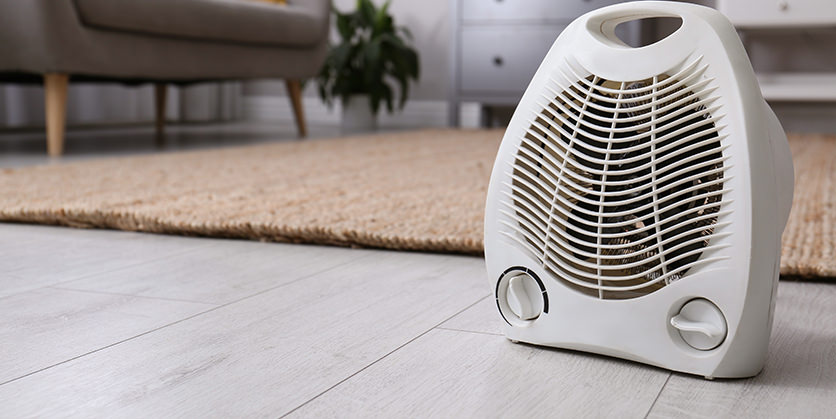 Closeup of an electric space heater on a wooden floor in the home