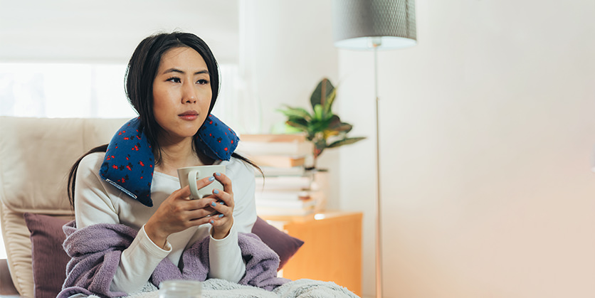 Woman sitting with a blanket and a warming cloth rice bag