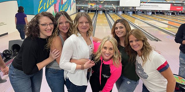 Group of women posing at a bowling alley and smiling