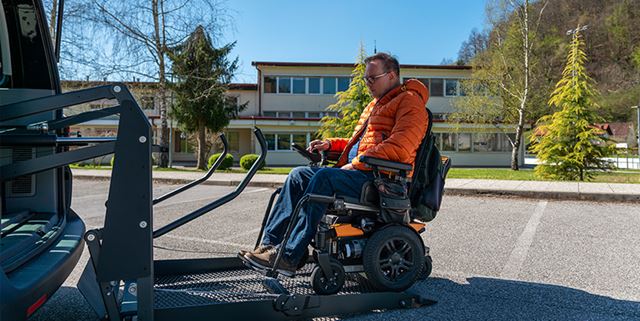 Man in a motorized wheelchair entering a van on an electric lift