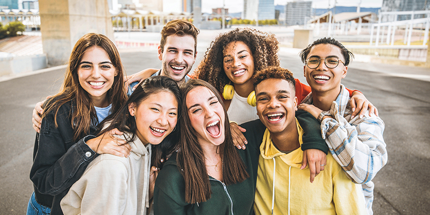 Group of smiling friends taking selfie outdoors