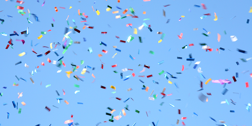 Multicolored confetti on a solid blue background