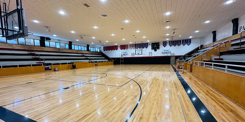 School gym with empty bleachers and the lights on