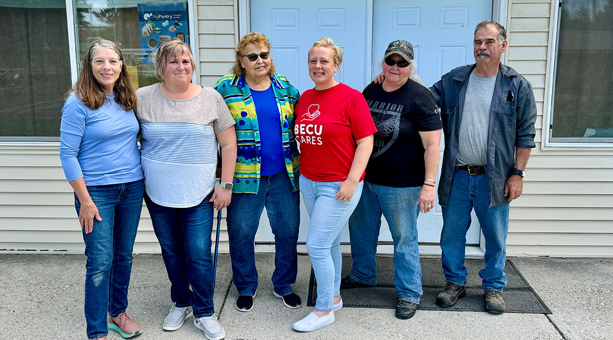 Six smiling people stand outside of Springdale Food Pantry.
