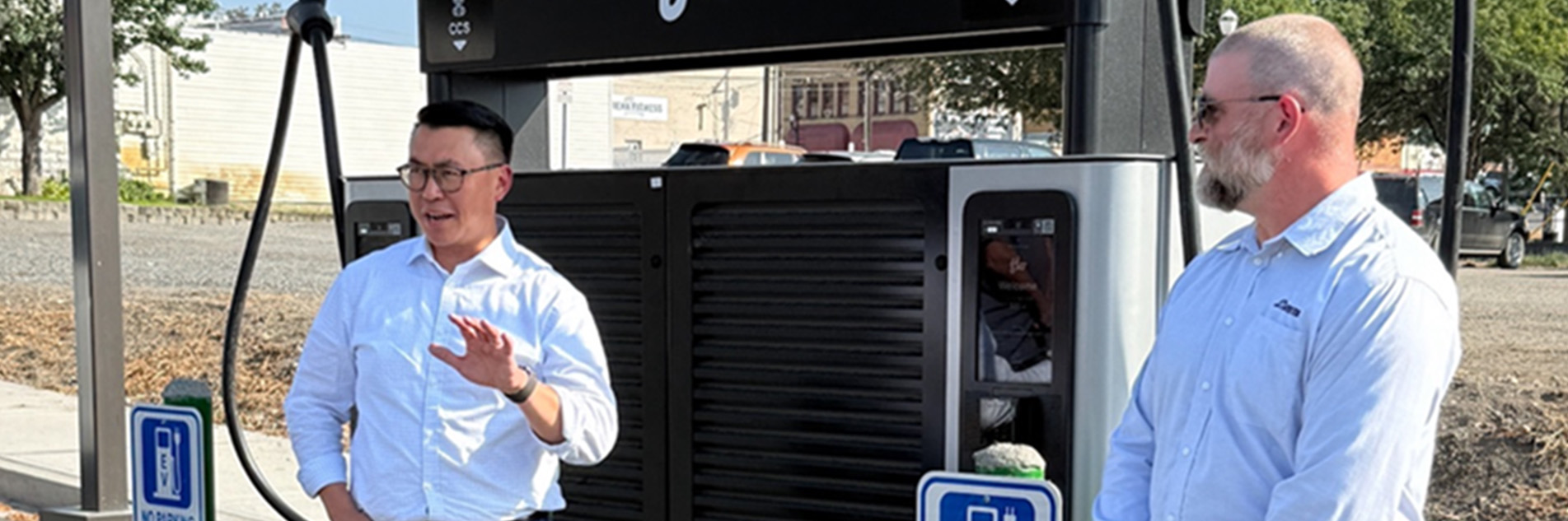 Two men stand in front of a Flo Ultra DCFC fast charging station for electric vehicles in Colville, WA.