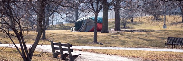 Tent set up in park during the fall season.