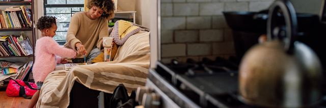 Mother and child color in their family room at home in the background with a natural gas stove is in the foreground.