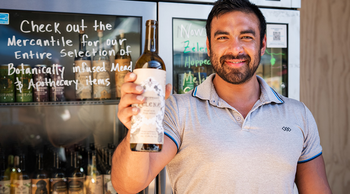 Scale House Market vendor Hierophant Meadery shows off one of their bottles of mead. 