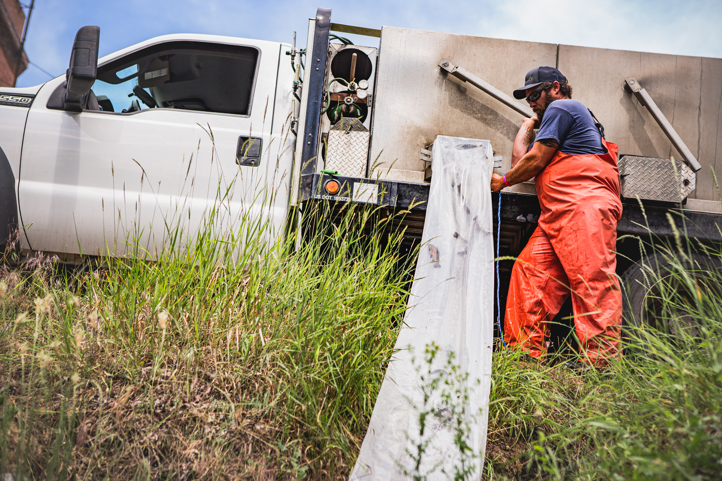 Man stands by a truck and begins to stock fish in the lake