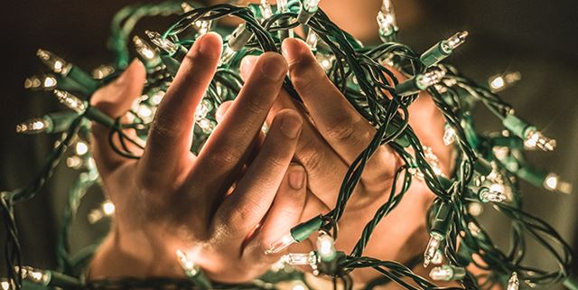 Hands holding holiday lights