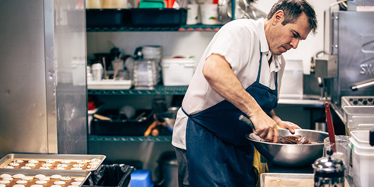 Man making dessert in large kitchen