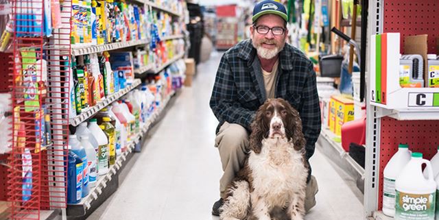 Man smiling with dog in hardware store