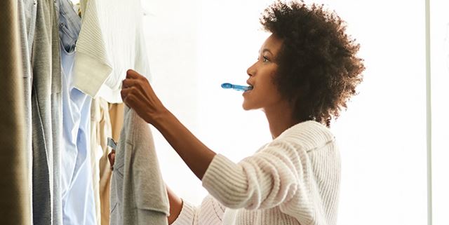 Woman hanging clothes on indoor drying line