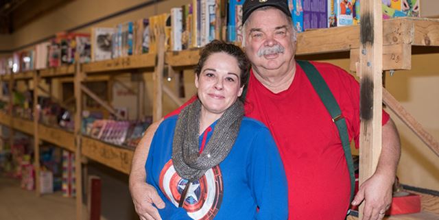 Man and woman smiling in a Toys for Tots warehouse