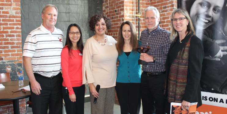People posing with award