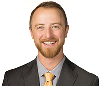 Christian smiling in front of a white background