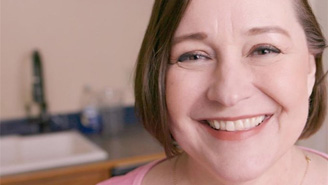 Closeup of woman's face, smiling, in the kitchen