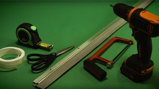 Supplies to seal up leaky windows laid out on a green background