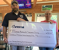 Two people hold up a giant cheque from Avista.
