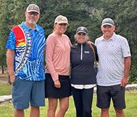 Group of people smiling on a golf course.