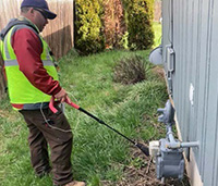 Man in yard checking natural gas meter